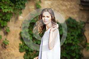 Portrait of lovely urban girl in short white dress in the street