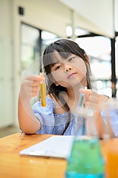 Portrait, Lovely young Asian girl holding text tubes, doing an interesting science experiment