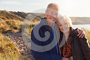 Portrait Of Loving Active Senior Couple Walking Through Sand Dunes  In Autumn Together