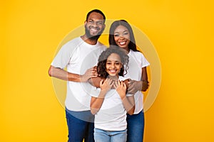 Happy black husband posing with wife and smiling daughter