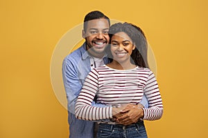 Portrait Of Loving Black Man And Woman Embracing And Smiling At Camera