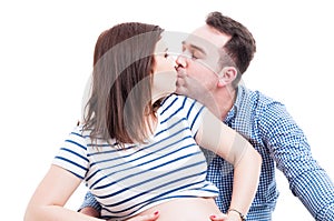 Portrait of loving couple with future dad kissing his wife