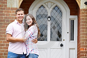 Portrait Of Loving Couple Standing Outside Home