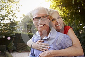 Portrait Of Loving Mature Couple In Back Yard Garden