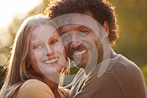 Portrait Of Loving Mature Couple Hugging Outdoors Against Flaring Evening Sun