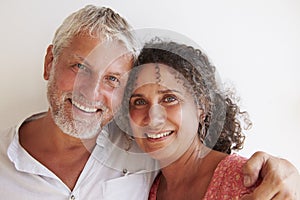 Portrait Of Loving Mature Couple Standing Against Wall