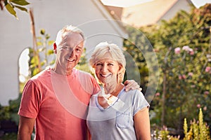 Portrait Of Loving Retired Couple Working In And Enjoying Summer Garden At Home