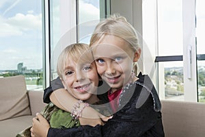 Portrait of loving siblings in dinosaur and vampire costumes at home