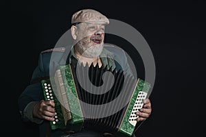 Portrait low key of an old retired military man singing while playing accordian