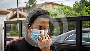 A portrait of Malay man with Kurta shirt wearing a 3 layer face mask during the Eid al-Fitr celebration