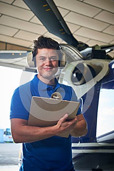 Portrait Of Male Aero Engineer With Clipboard Carrying Out Check