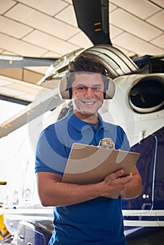 Portrait Of Male Aero Engineer With Clipboard Carrying Out Check