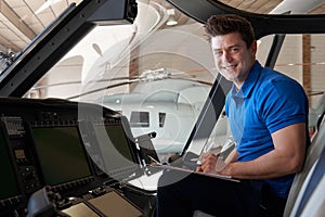 Portrait Of Male Aero Engineer With Clipboard Working In Helicopter Cockpit