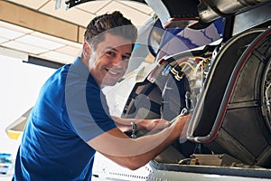 Portrait Of Male Aero Engineer Working On Helicopter In Hangar