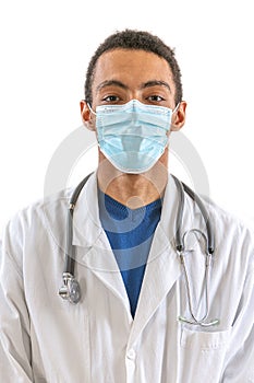 Portrait of male afro american doctor with stethoscope, mask and lab coat. Young doctor looking at camera. Man standing on white