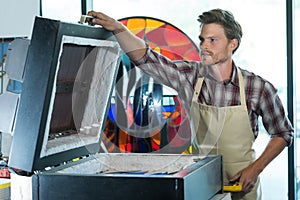 portrait male artist working on painting in studio