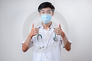 Portrait of male asian young doctor with thumbs up wears medical face mask