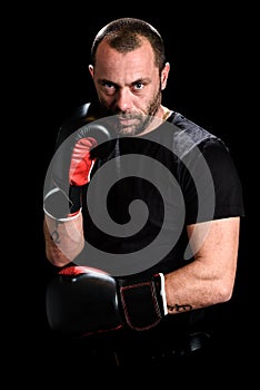 Portrait of male athlete boxer man looking aggressive with boxing gloves on.
