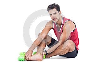 Portrait of male athlete with foot pain on white background