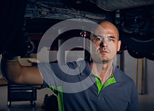 Portrait of male auto repair mechanic worker posing at workplace