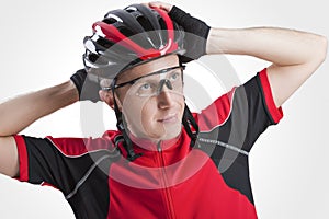 Portrait of Male Caucasian Cyclist Posing in Red Road Protective Helmet and Glasses.