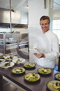 Portrait of male chef using digital tablet at order station