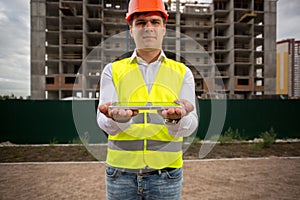 Portrait of male construction engineer holding digital tablet. Perfect for inserting your own image on tablet screen