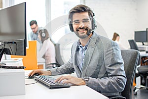 Portrait of male customer service helpline operator in call center