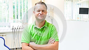 Portrait of male dentist with hands crossed looking in camera