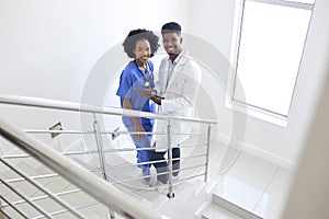 Portrait Of Male Doctor And Female Nurse With Digital Tablet On Stairs In Hospital