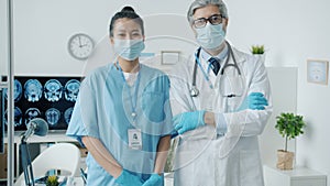 Portrait of male doctor and female nurse standing in hospital office