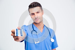 Portrait of a male doctor holding pills