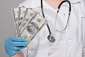 A portrait of a male doctor with money in his pocket isolated on white background