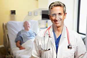 Portrait Of Male Doctor With Patient In Background