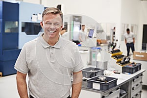 Portrait Of Male Engineer On Factory Floor Of Busy Workshop