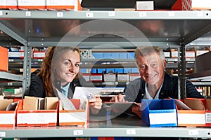 Portrait Of Male Engineer With Female Apprentice Checking Stock Levels  Using Digital Tablet