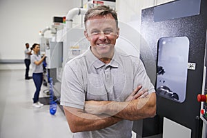 Portrait Of Male Engineer Operating CNC Machinery In Factory