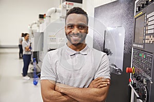 Portrait Of Male Engineer Operating CNC Machinery In Factory