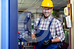 Portrait Of Male Engineer Operating CNC Machinery In Factory