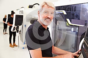 Portrait Of Male Engineer Operating CNC Machinery In Factory