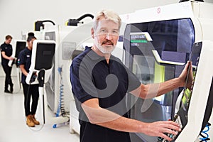 Portrait Of Male Engineer Operating CNC Machinery In Factory