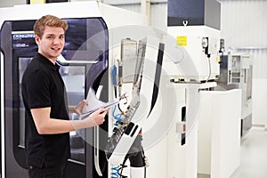 Portrait Of Male Engineer Operating CNC Machinery In Factory