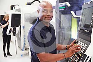 Portrait Of Male Engineer Operating CNC Machinery In Factory