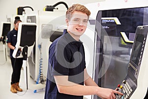 Portrait Of Male Engineer Operating CNC Machinery In Factory