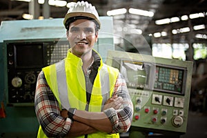 Portrait of male Engineer standing with confident against machine environment in factory