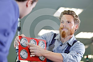 Portrait male engineer working on machine in factory