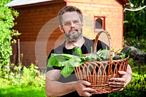 Portrait of a male farmer holding a basket of vegetables.Harvest of ecologically clean ripe vegetables and fruits