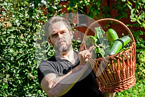 Portrait of a male farmer holding a basket of vegetables.Harvest of ecologically clean ripe vegetables and fruits