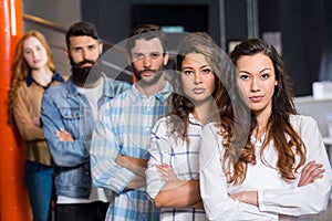 Portrait of male and female executives standing with arms crossed