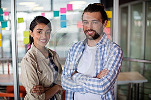 Portrait of male and female executives standing with arms crossed